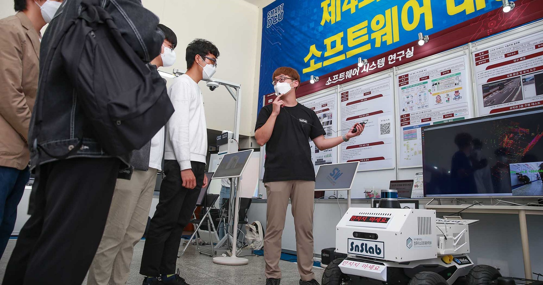 제4회 DCU 소프트웨어 대전에서 참가 학생들이 전시물의 설명을 듣고 있다